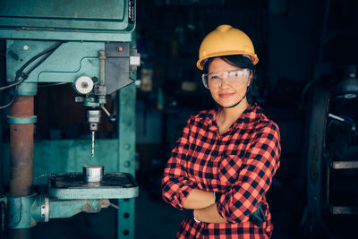 Portrait of senior man standing at machine