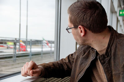 Man looking through window at airport