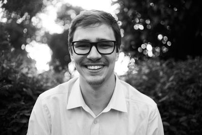 Portrait of smiling young man wearing eyeglasses outdoors