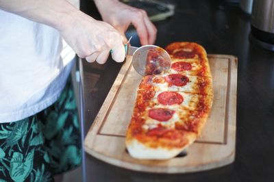 Midsection of man holding pizza