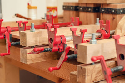 Close up of carpenter fastening board with clamps. carpentry workshop