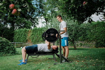 Two men working out together at home outside in the garden