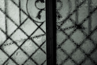 Full frame shot of metal fence against wall