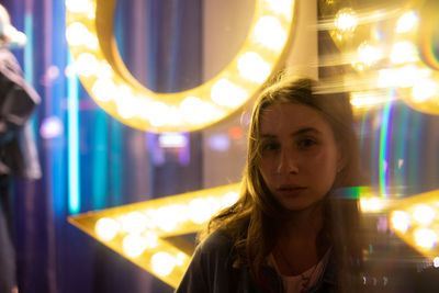 Portrait of woman with illuminated lights at night