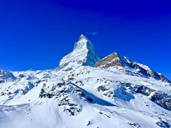 Scenic view of snowcapped mountains against clear blue sky