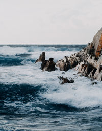 Rocks in sea against sky