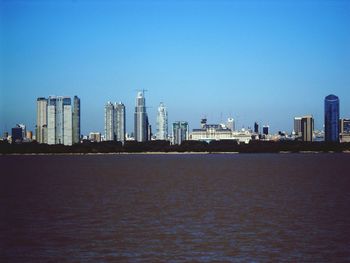 View of cityscape against clear blue sky