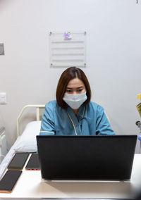 Illness asian patient women still  using laptop for working hard  in patient room of hospital