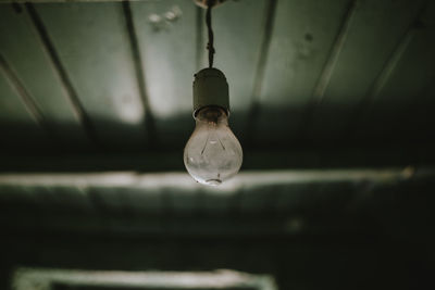Close-up of light bulb hanging from ceiling