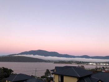 Scenic view of sea and buildings against sky during sunset