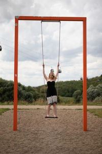 Full length of boy standing on field against sky