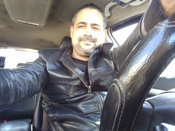 Young man sitting in car