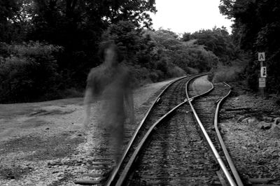 Blurred motion of man walking on railroad track