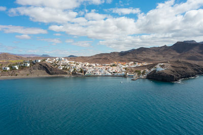 Scenic view of sea and mountains against sky
