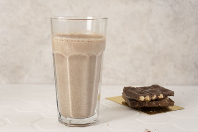 Delicious homemade cocoa drink with milk, cocoa powder and pieces of chocolate bar. close-up.