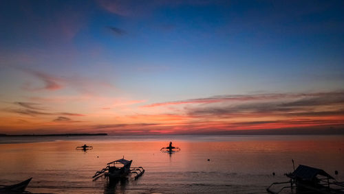 Scenic view of sea against dramatic sky during sunset