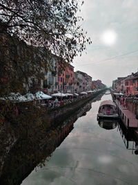 River amidst buildings in city against sky