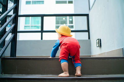 Rear view of boy moving up on staircase