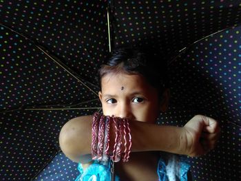 Close-up portrait of cute girl standing under umbrella