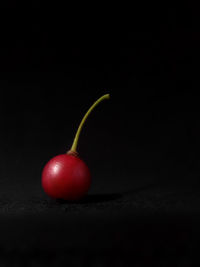 Close-up of cherries on table against black background