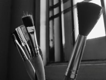 Close-up of make-up brushes against window