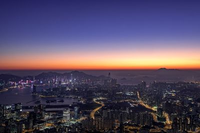 High angle view of illuminated city against sky during sunset