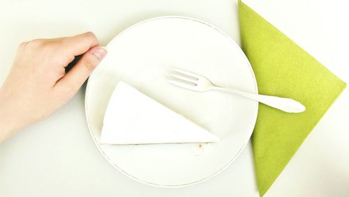 Cropped image of hand by dessert served on table