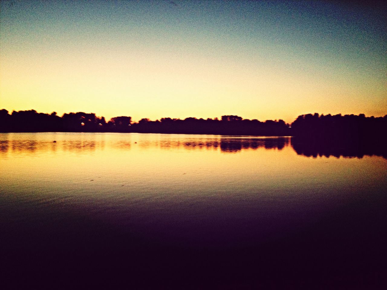 sunset, water, reflection, clear sky, tranquil scene, lake, tranquility, scenics, copy space, silhouette, beauty in nature, waterfront, nature, idyllic, calm, standing water, orange color, dusk, river, tree