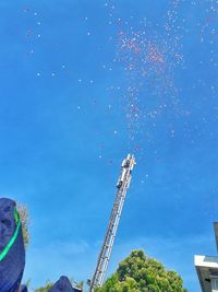 Low angle view of communications tower against blue sky