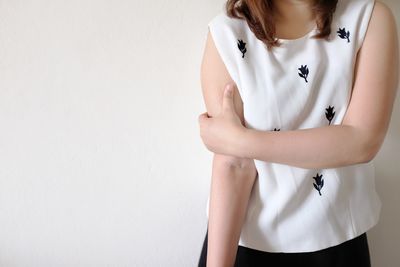 Midsection of woman standing against white background