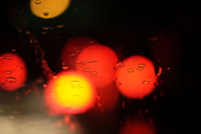 Close-up of water drops on illuminated christmas lights