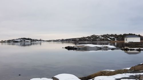 Scenic view of lake against sky during winter