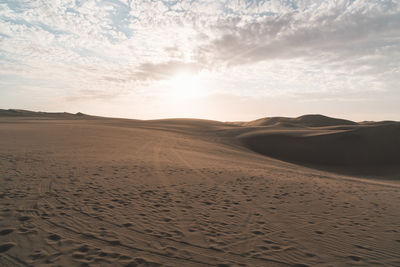 Scenic view of desert against sky during sunset