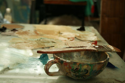 Close-up of cup and brush on table