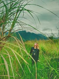 Woman standing on field against sky