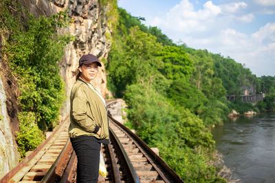 Portrait of woman standing on railroad tracks