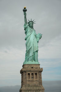 Low angle view of statue of liberty against sky