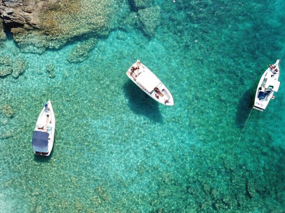 HIGH ANGLE VIEW OF SAILBOATS IN SEA