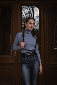 Portrait of a smiling girl holding open door