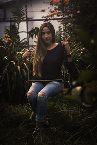 Portrait of beautiful young woman sitting on land