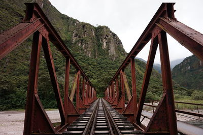 Railroad track by bridge against sky