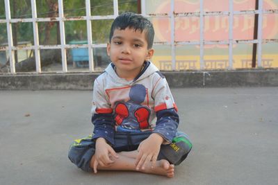 Portrait of cute boy sitting outdoors