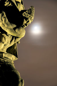 Low angle view of illuminated statue against sky