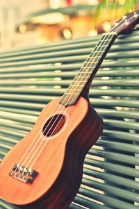 Close-up of acoustic guitar on bench