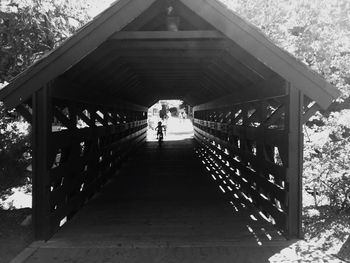 Rear view of people walking on footbridge