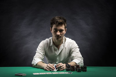 Portrait of man playing with cards at table