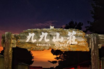 Low angle view of illuminated text against sky at night