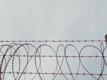 Low angle view of barbed wire against clear sky