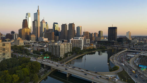 Aerial view of modern buildings in city against sky during sunset