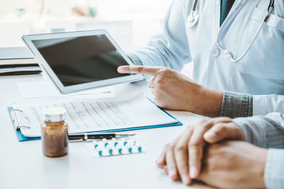 Midsection of man using laptop on table